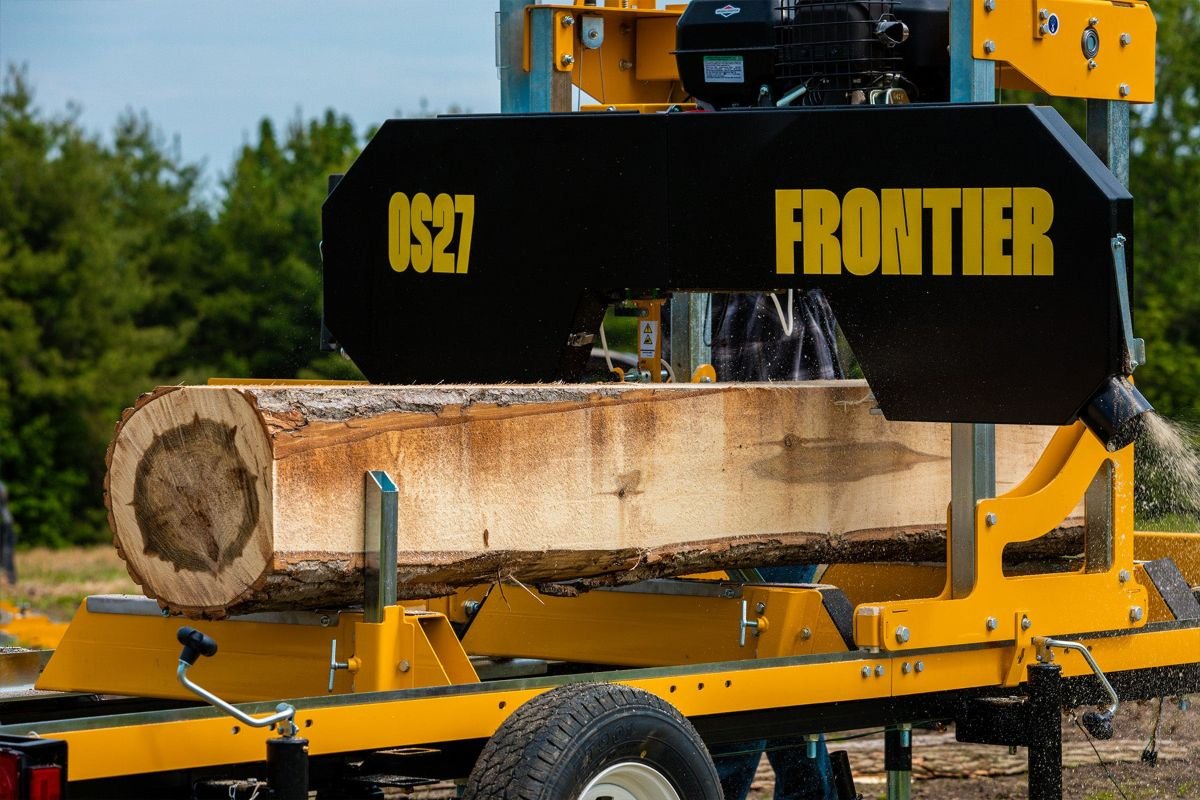 Frontier OS27 portable sawmill with a log on the bed