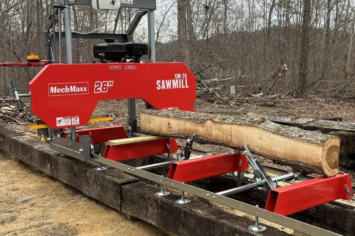 MechMaxx SM-26 sawmill with a log on the bed in a wooded yard