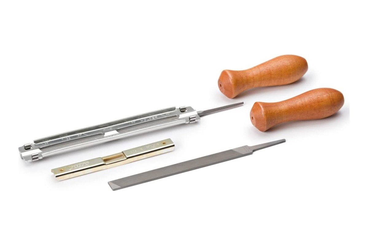 Oregon chainsaw sharpening kit with a round file in its guide, a flat file, a depth gauge and two handles