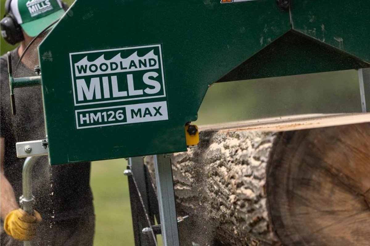 Woodland Mills HM126MAX sawhead cutting a board from a log, sawdust flying